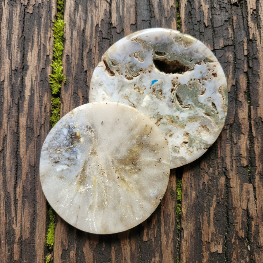 Two agate decorative bowls with a natural, marbled appearance, placed on a textured surface.