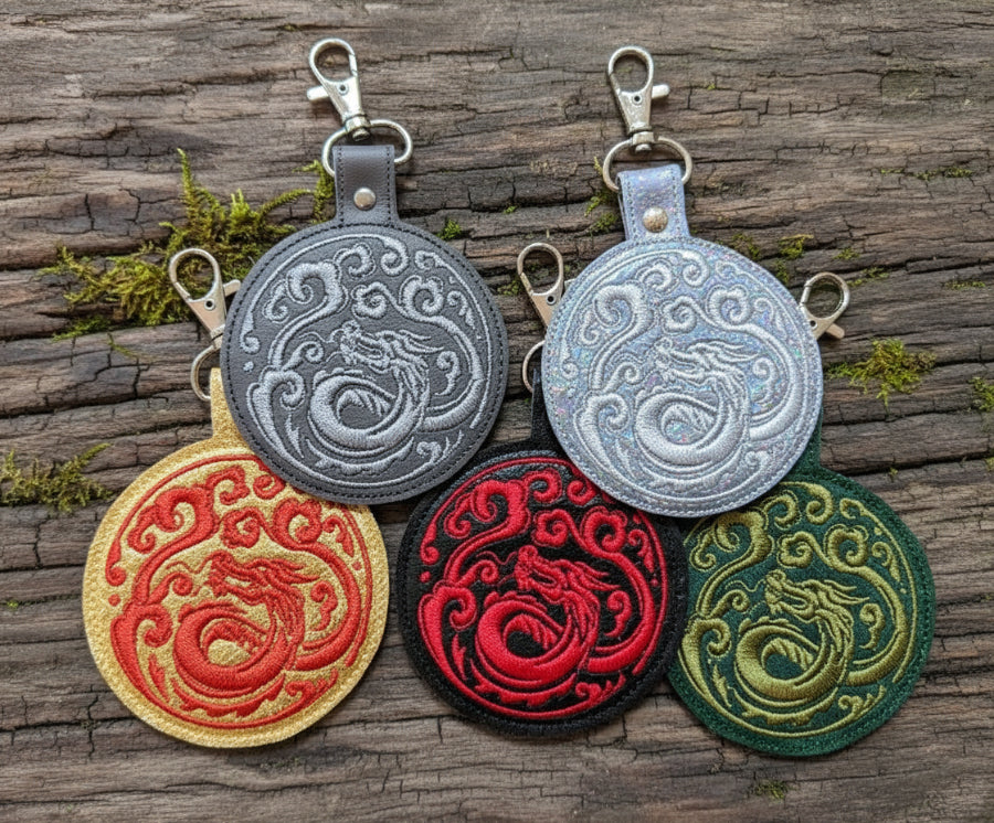 A collection of keychains with dragon designs, featuring intertwining dragon patterns, crafted with Egyptian cotton thread and stainless steel lobster clasps.