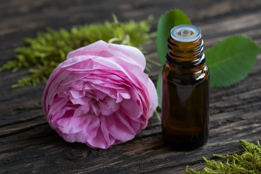 A 5ml bottle of Rose Essential Oil with a pink rose next to it.