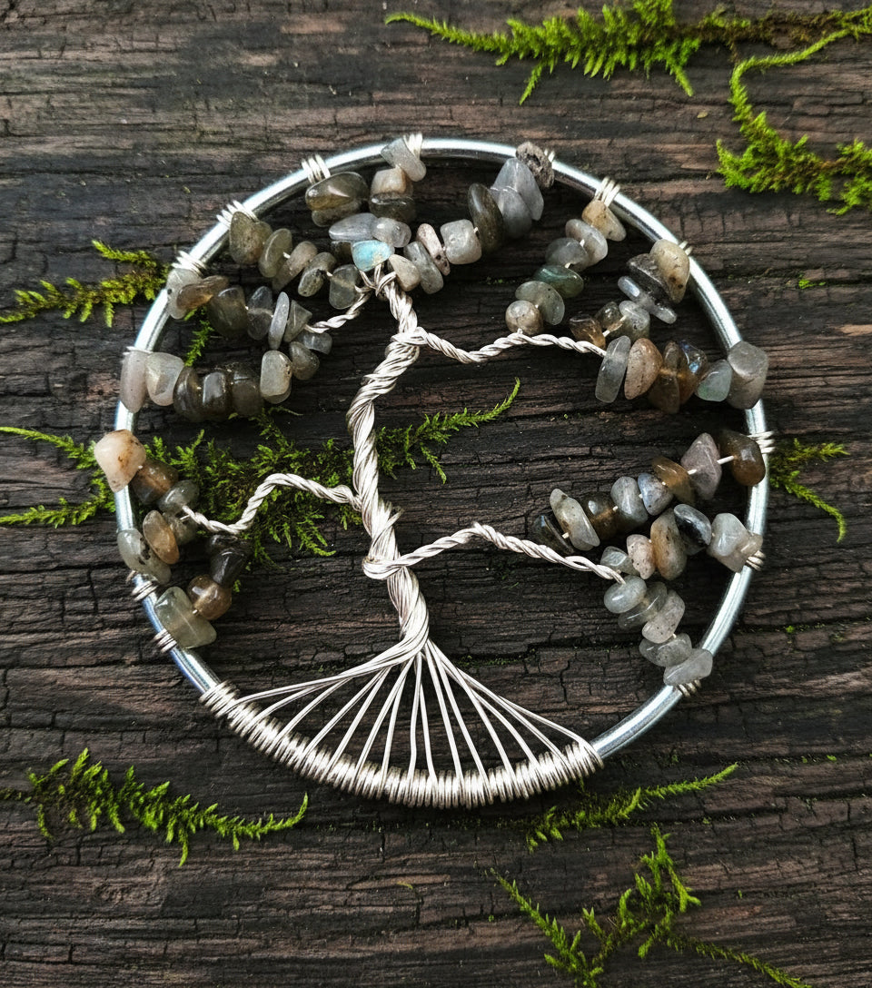 A silver suncatcher with a tree-like design made of blue labradorite crystals, with butterflies flitting amongst the branches.